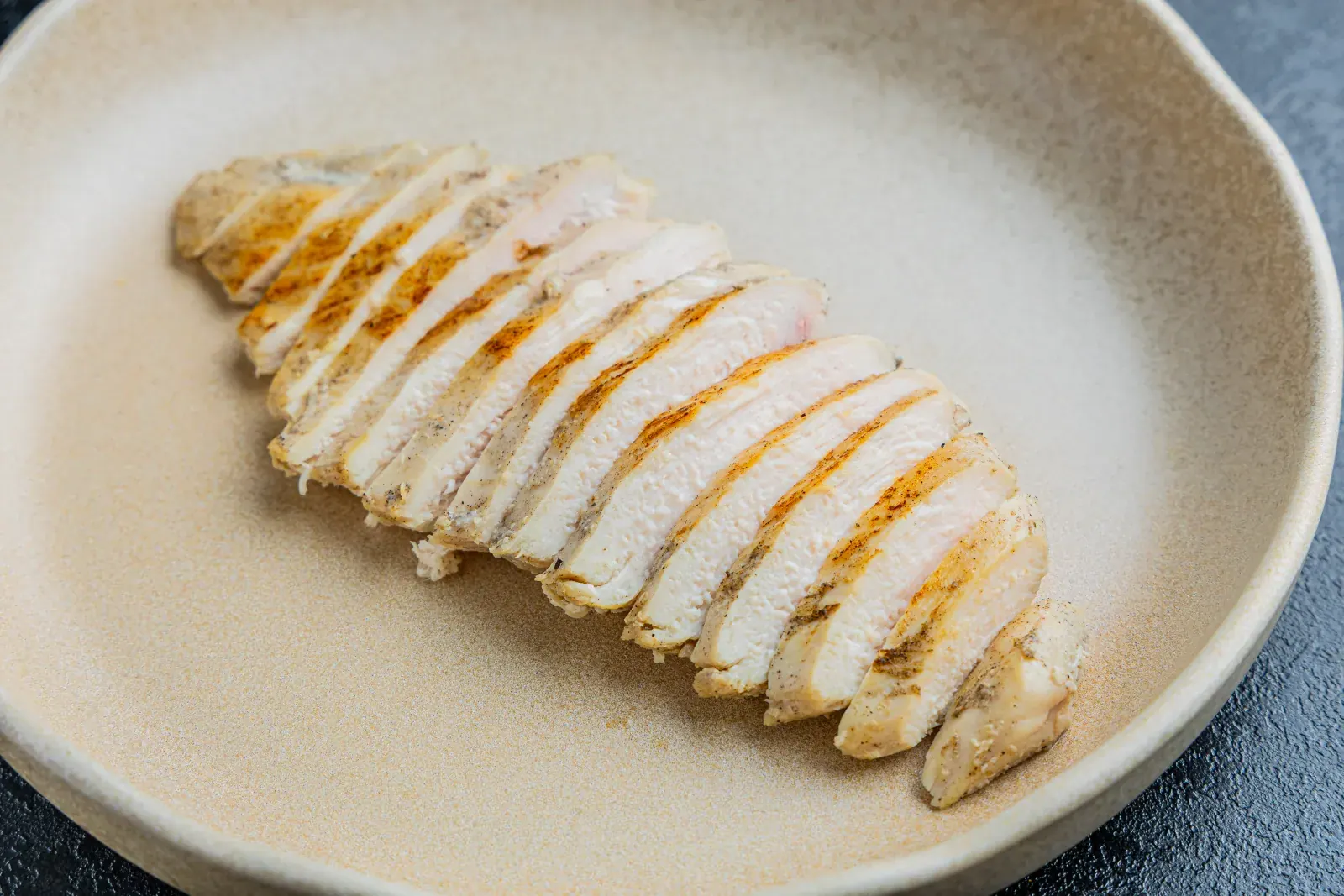 Real Easy Meat seasoned chicken fillet, sliced on a plate
